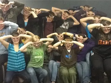 Máximo de personas haciendo antifaces con las manos en un sofá Máximo de personas haciendo antifaces con las manos en un sofá