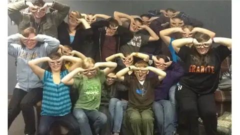 Máximo de personas haciendo antifaces con las manos en un sofá Máximo de personas haciendo antifaces con las manos en un sofá