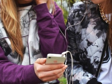 Unas jóvenes con un teléfono móvil