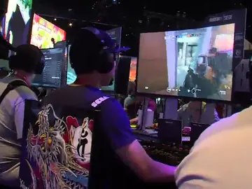 Un grupo de jóvenes jugando a videojuegos en una convención Un grupo de jóvenes jugando a videojuegos en una convención