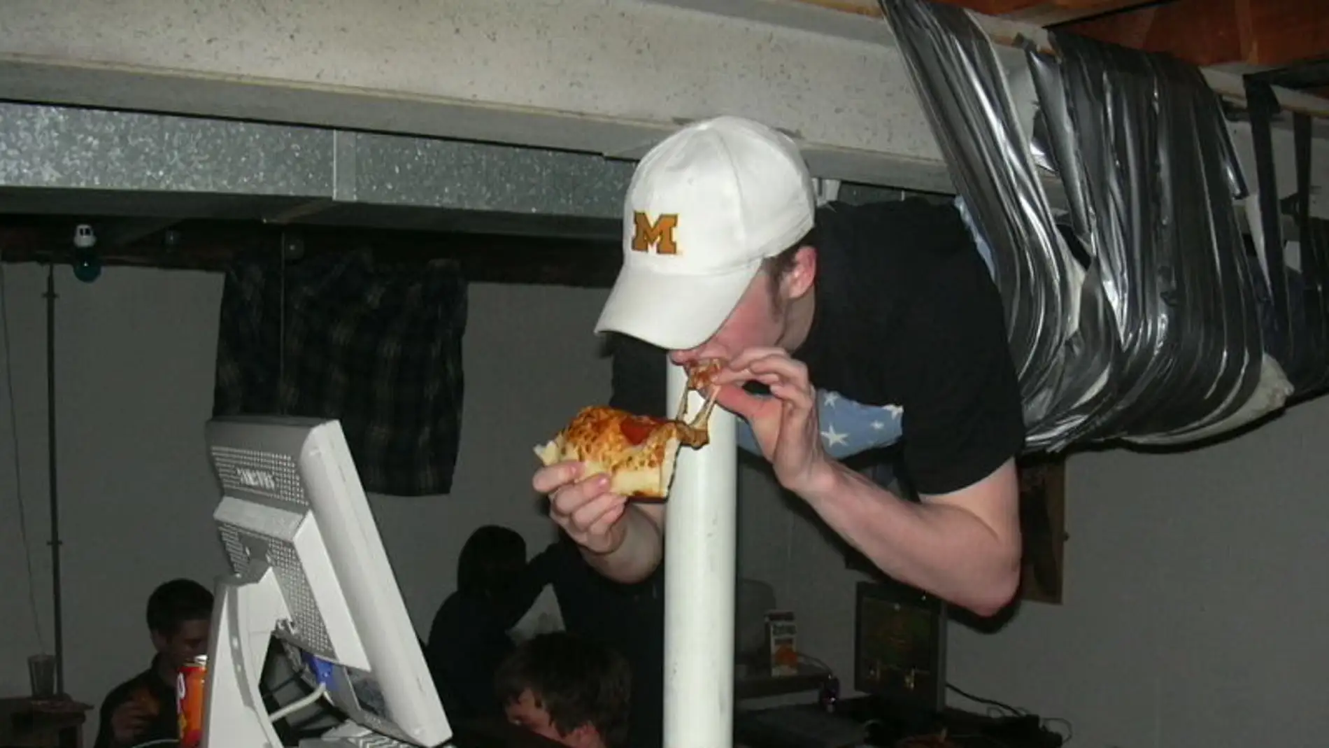 Persona comiendo pizza mientras juega al PC