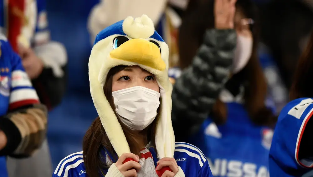 Una aficionada japonesa se protege de un posible contagio de coronavirus con una mascarilla