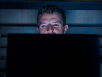 Hombre mirando el ordenador a oscuras