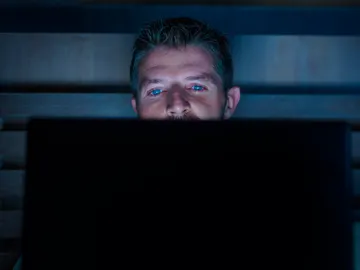 Hombre mirando el ordenador a oscuras Hombre mirando el ordenador a oscuras