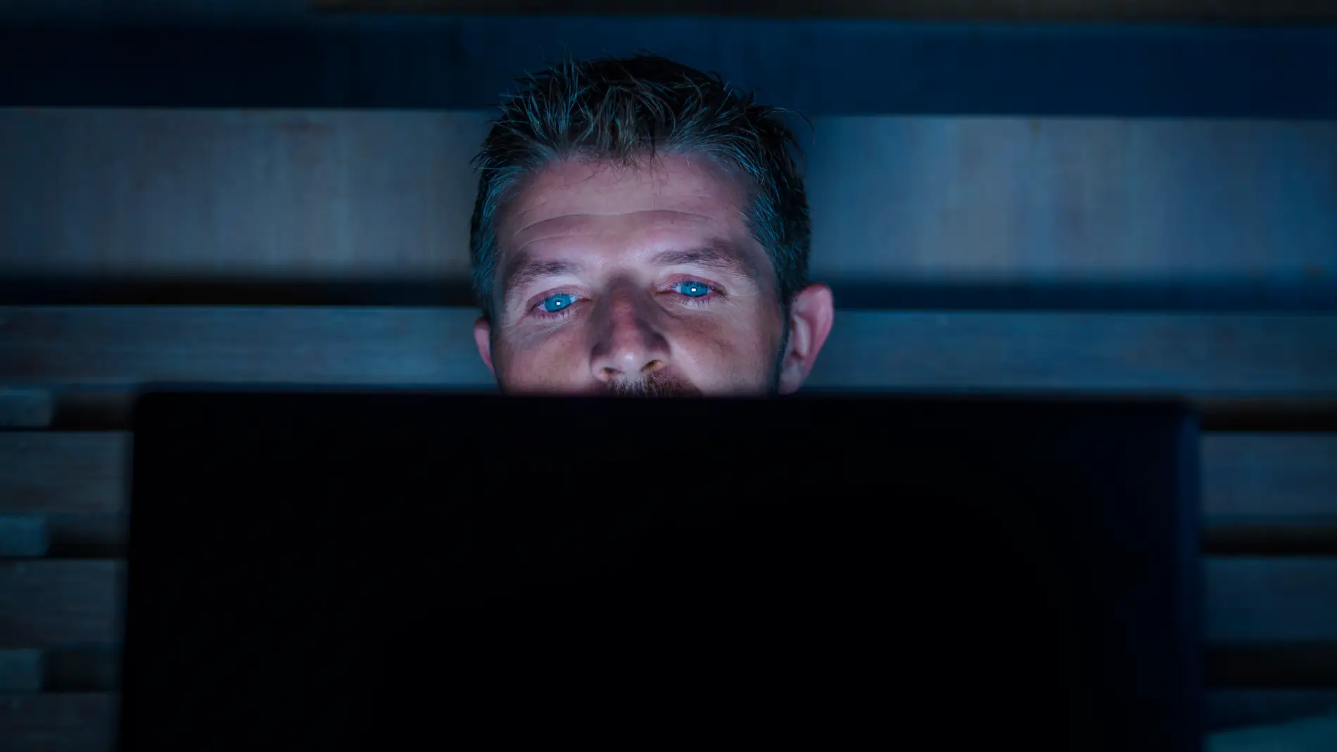 Hombre mirando el ordenador a oscuras