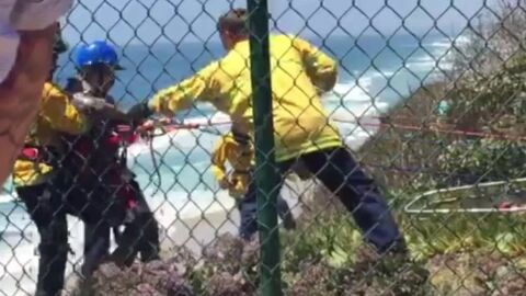 Bomberos rescatando a uno de los jóvenes