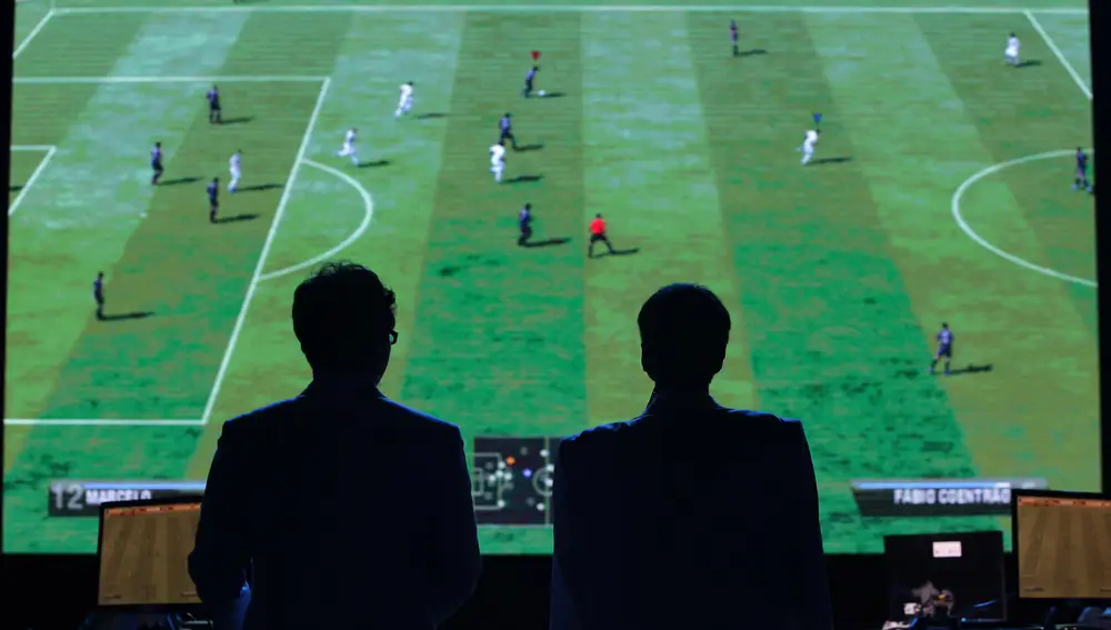 Dos hombres observan un partido del FIFA durante una competición de eSports