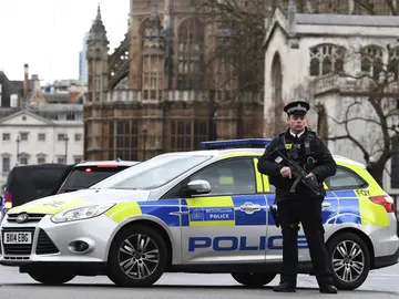 Policía británico junto al coche Policía británico junto al coche