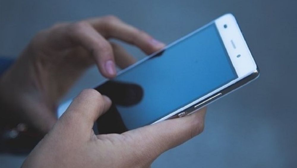 Imagen de archivo de una persona con un teléfono móvil en la mano
