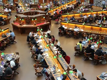 Estudiantes en una biblioteca Estudiantes en una biblioteca
