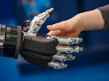 Mano robótica estrechando mano humana Mano robótica estrechando mano humana